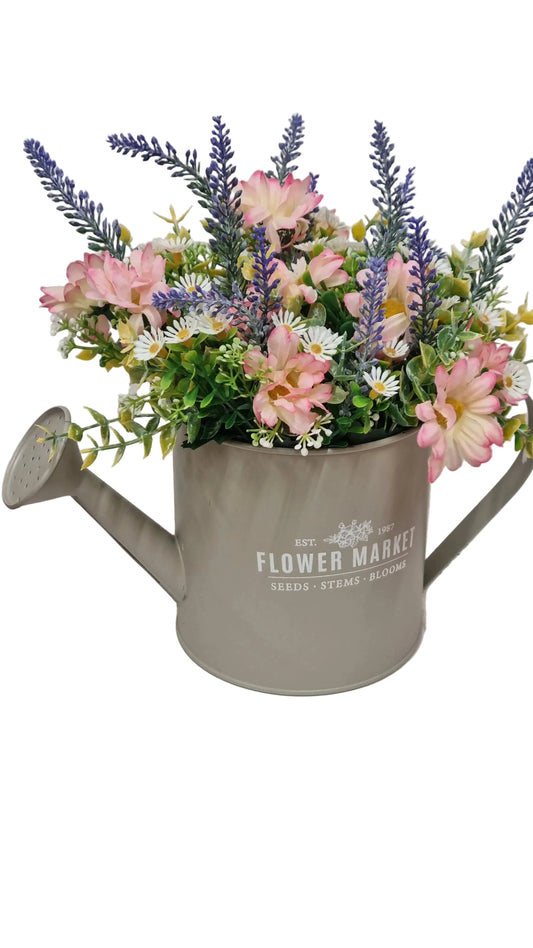 Composizione floreale artificiale con fiori rosa, lavanda e margherite in annaffiatoio metallico decorativo