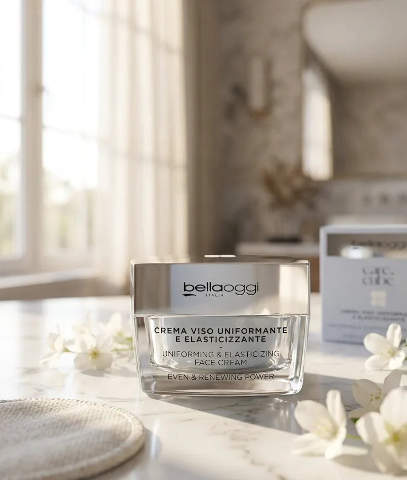 Crema viso uniformante e elasticizzante Bellaoggi Italia su marmo con fiori bianchi