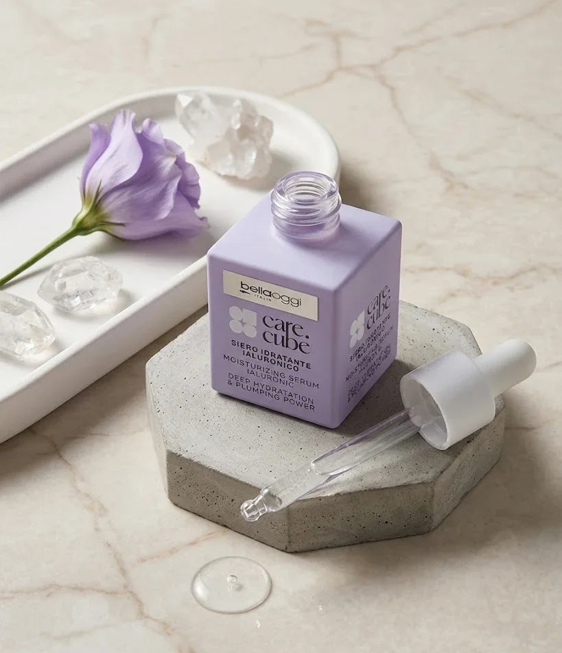 Siero idratante all’acido ialuronico Bellaoggi Care Cube, con pipetta, su base in cemento e fiore viola