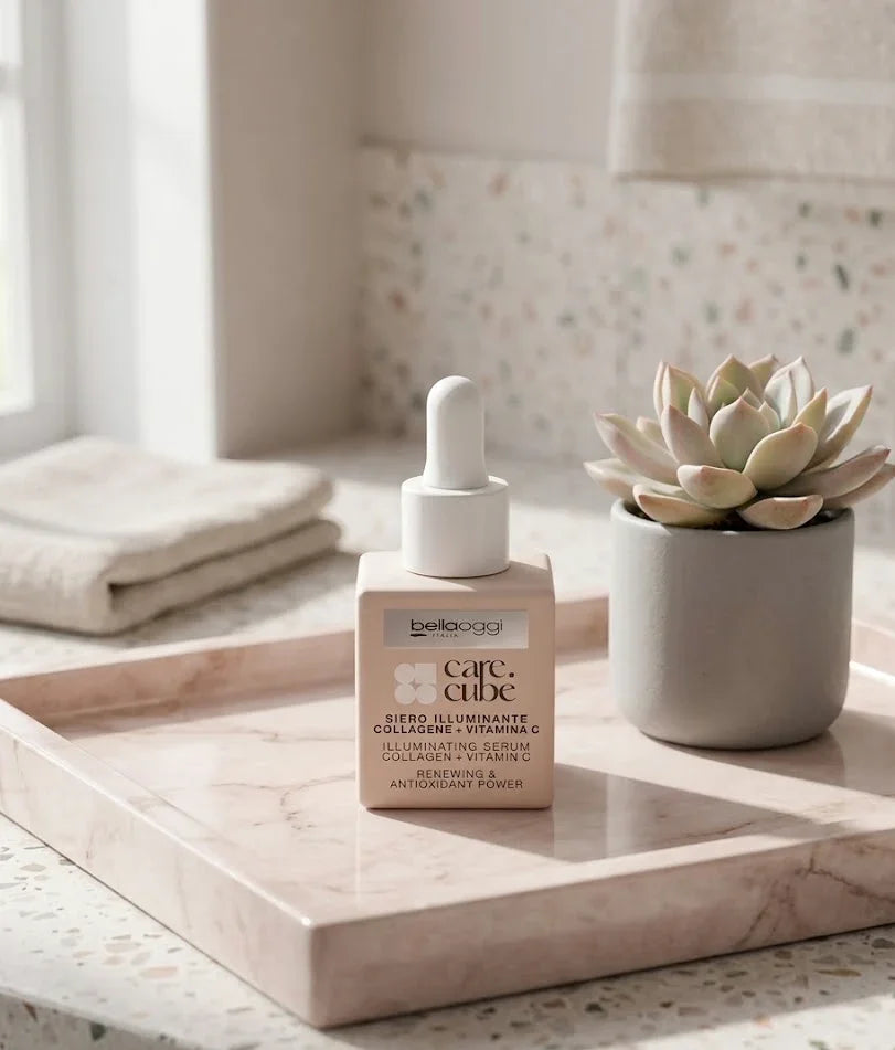 Siero illuminante con collagene e vitamina C su vassoio in bagno, accanto a pianta succulenta